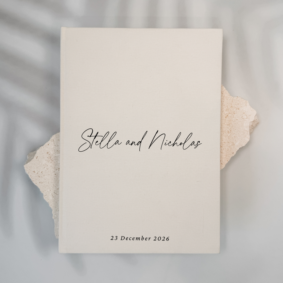 Off-white linen personalised wedding guest book with script lettering, portrait format