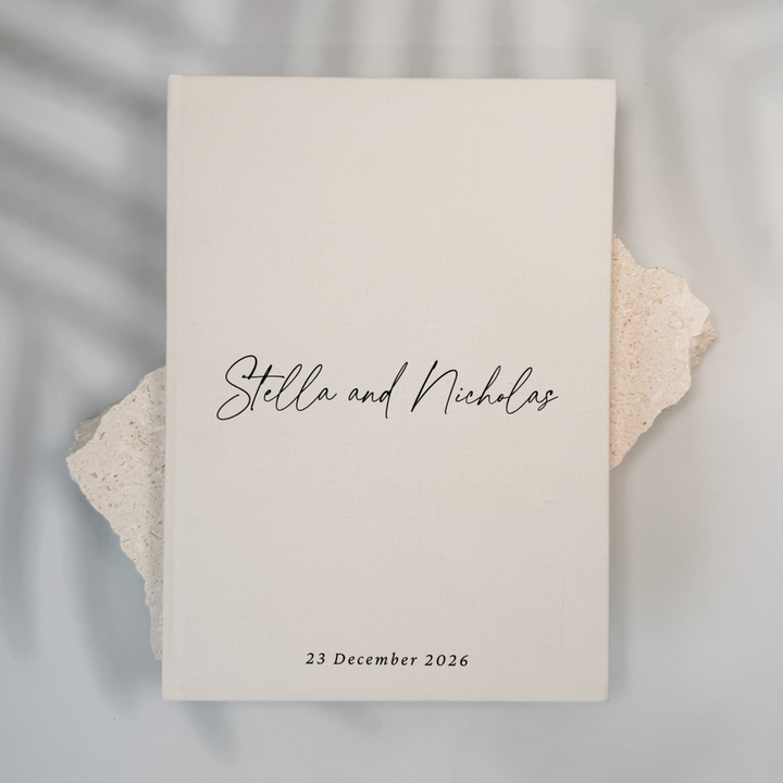 Off-white linen personalised wedding guest book with script lettering, portrait format