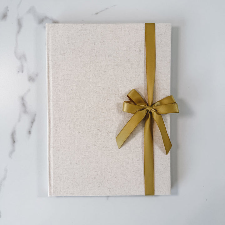 Gold satin ribbon bow on guest book